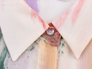 Détail du col rabattu et imprimé aquarelle sur une robe cache-cœur sans manches