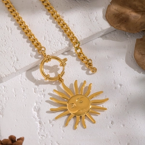 Vintage gold sun face pendant necklace with cuban chain and T-bar clasp on stone