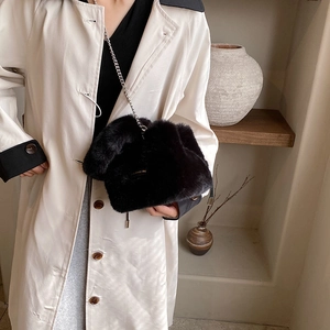Chic black plush bucket bag for women with golden chain strap and drawstring detail