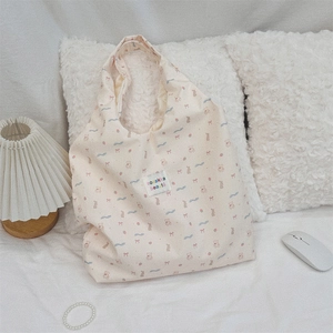 Détail du sac cabas floral avec motifs d'animaux mignons et étiquette de marque