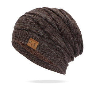 Detail of dark brown knitted beanie with thick fleece lining and leather label