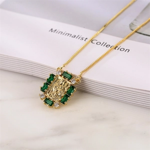 Detail of gold pendant with green emerald-cut zircon and vintage embossed religious icon