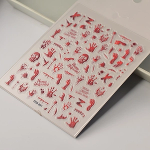 Macro view of 3D Halloween blood hand and skull nail stickers on transparent sheet