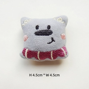 Detail of grey embroidered plush cartoon badge with 4.5cm x 4.5cm size and striped pattern