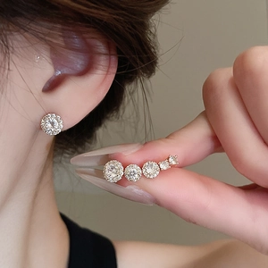 Detailed view of elegant gold-plated zircon stud earring and matching ear cuff on model