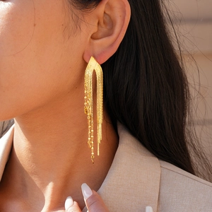 Gros plan de boucles d'oreilles à pampilles multicouches plaquées or 18 carats