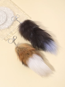 Close-up of oversized fluffy faux fur fox tail keychains in brown and black gradients