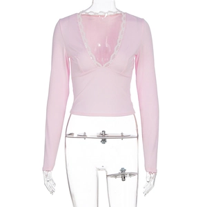 Detail of pink V-neck top showing delicate white lace trim and ribbed knit texture