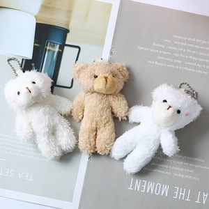 Detail of plush teddy bear charms with blush cheeks and soft texture in white and brown
