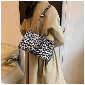 Detail of leopard print leather bag with gold T-logo and silver chain shoulder strap