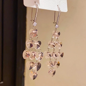 Detail of silver drop earrings with tiered pink heart crystals and tassel design