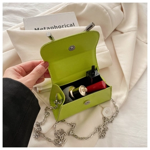 Close-up of mini green trapezoid bag showing interior space for lipstick and cosmetics