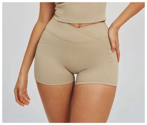 Macro detail of high-waist yoga shorts with cross-over V-waistband and side pockets