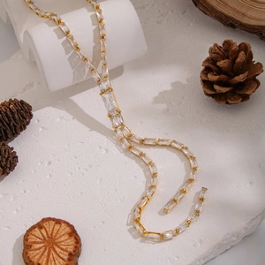 Elegant gold bamboo style necklace with hand-set cubic zirconia and tassel drop design