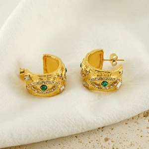 Chunky gold malachite evil eye hoop earrings with cubic zirconia on white linen backdrop
