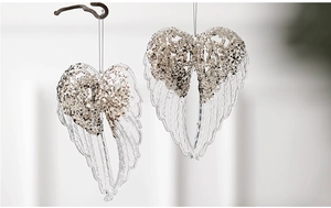 Macro shot of transparent acrylic angel wings with champagne gold glitter Christmas ornaments