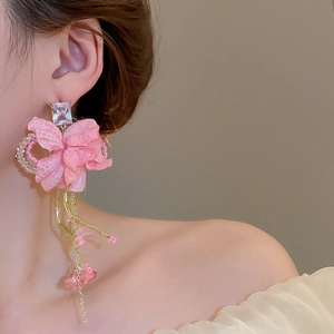 Detailed close-up of pink fabric flower tassel earrings with rhinestone and bead accents