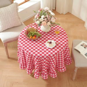 Red and white checkered round tablecloth with ruffled edges on a dining table
