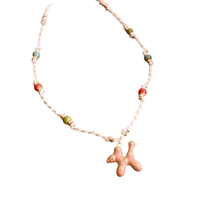Pastel beaded cord necklace featuring a cute ceramic puppy pendant with gold flowers
