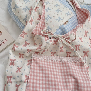 Détail du sac cabas floral avec nœuds roses et poche vichy bordée de dentelle