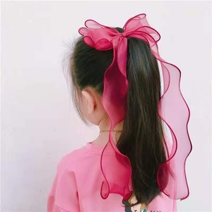 Deep pink organza bow hair clip with ribbons for girls shown on a ponytail back view