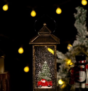 Detail of vintage bronze Christmas lantern with red truck and swirling glitter snow