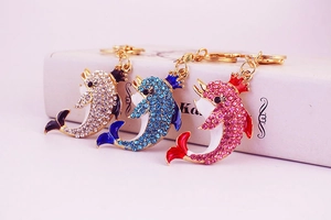 Macro detail of crown dolphin keychains with colorful rhinestones and enamel coating