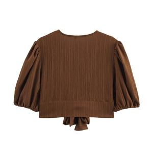Detail of dark brown cropped top with puffed sleeves and textured pleated fabric