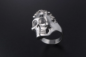 Detailed macro view of punk skull ring showing intricate bone textures and silver finish