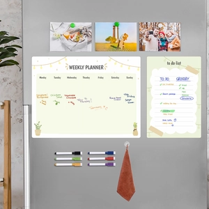 Magnetic weekly planner set with dry erase markers and towel on a grey refrigerator