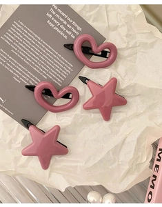 Lot de barrettes roses en forme de cœur et d'étoile sur un fond esthétique