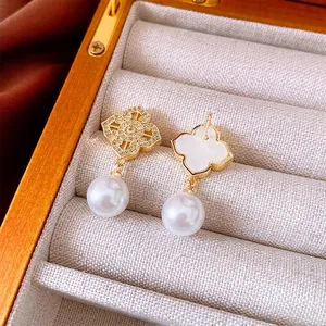 Vintage gold clover earrings with cubic zirconia and pearl pendants on velvet