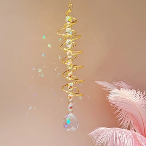 3D spiral wind spinner with crystal ball suncatcher hanging on pink background