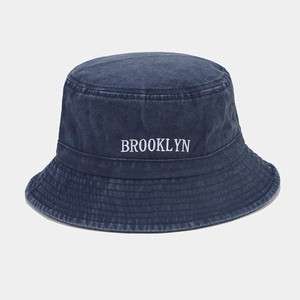 Détail de la broderie blanche BROOKLYN sur un chapeau bob en denim bleu délavé