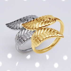 Macro detail of adjustable leaf-shaped rings in gold and silver stainless steel