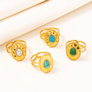Detail of adjustable gold rings with hammered texture and colorful inlaid gemstones