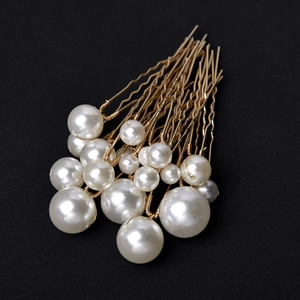 Set of 18 golden pearl hair pins with white pearls in various sizes on black background