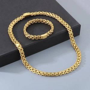 Close-up of 10mm golden stainless steel chain necklace and bracelet set in a gift box