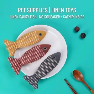 Three realistic burlap catnip fish toys for grinding teeth on a white ceramic plate