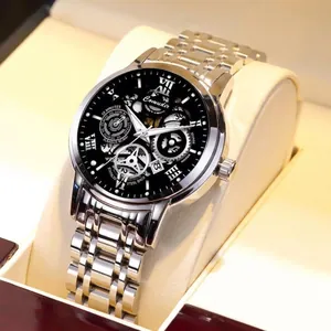 Detail view of Comudir automatic mechanical watch with black skeleton dial and silver band