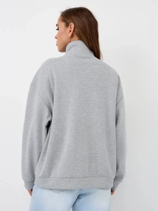 Detail view of the gray high collar sweatshirt back with ribbed cuffs and soft texture
