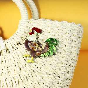 Fashionable acrylic rooster brooch with colorful enamel finish pinned to a woven bag