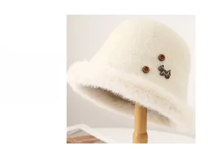 Dettaglio del cappello cloche in lana crema con bordo in peluche e decorazione a cane