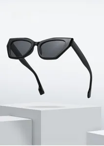 Macro shot of stylish black cat eye sunglasses displayed on white geometric platforms
