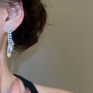 Close-up of silver tassel earrings with sparkling rhinestones and crystal waterdrop charms