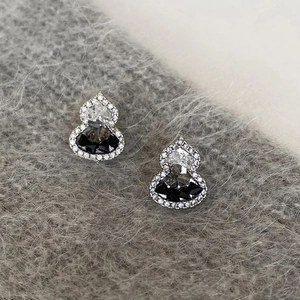 Elegant sterling silver gourd earrings with sparkling zircon crystals on soft grey fabric