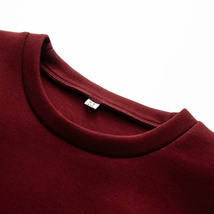Détail du col d'un sweat en maille bordeaux avec boucle métallique dorée élégante