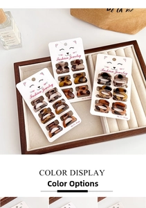 Macro view of mini leopard print hair claws on a fashion display card in a wooden tray