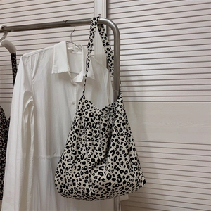 Dettaglio di una borsa tote in tela con stampa leopardata appesa a un appendiabiti in metallo