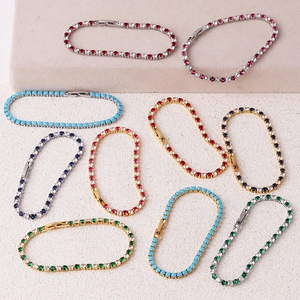 Flat lay of colorful 3.0 zircon tennis bracelets in gold and silver finish on beige texture